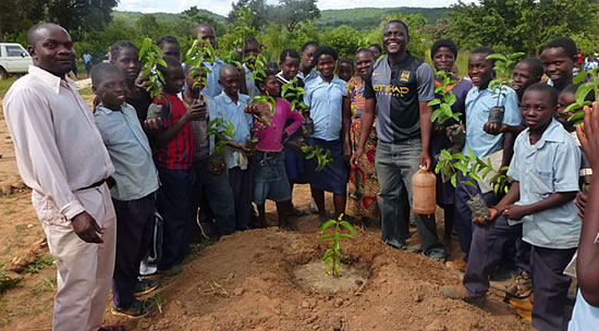 Families gather round a newly planted treed in Lower Zambezi – one of Air BP’s carbon offsetting projects.