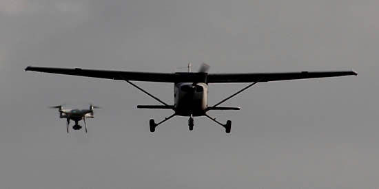A drone is shown encroaching on a small aircraft in flight